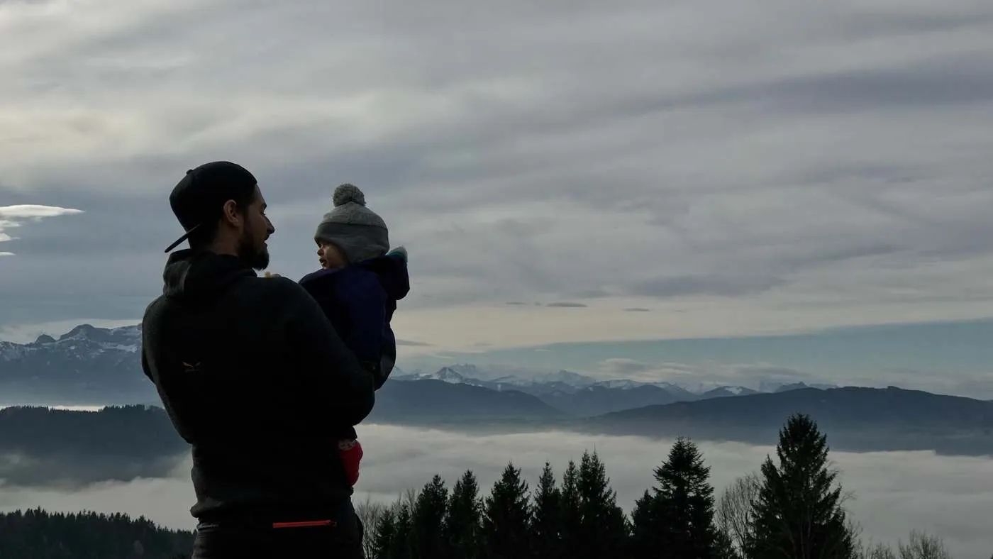 Parent holding a child above the clouds